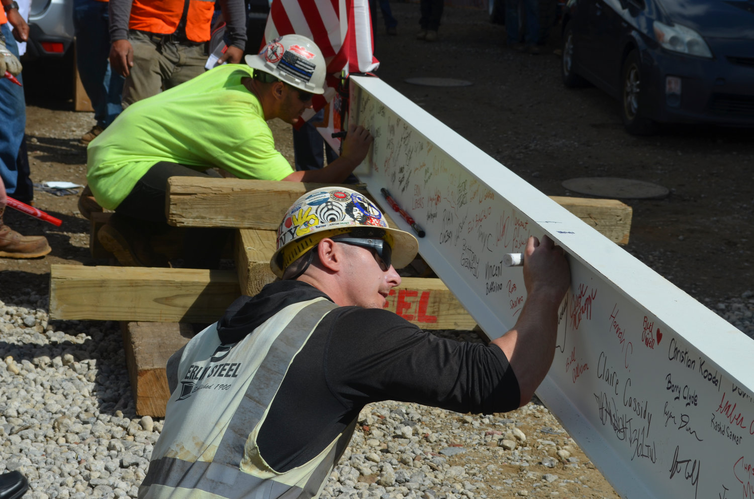 Construction workers Sal Gustella and Curran Digney sign their names onto the final beam steel beam of the J Wing Patient Pavilion as part of its topping out ceremony last week at Mount Sinai South Nassau in Oceanside. The pavilion will open in 2024.