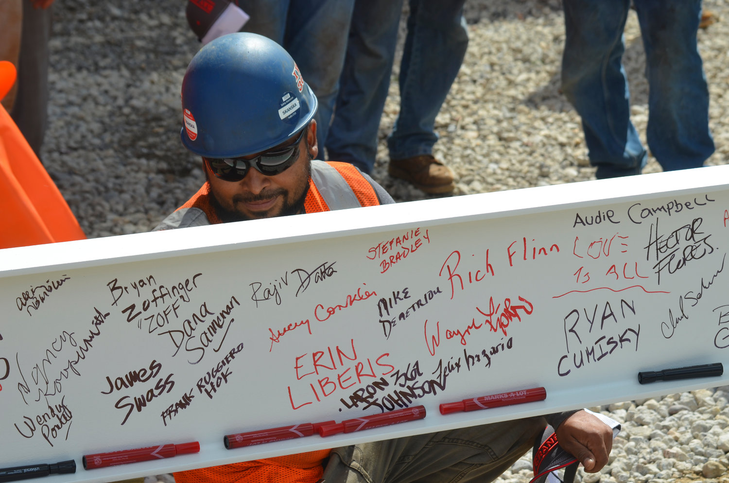 Construction worker Ryan Cuaseway signs his name onto the final beam steel beam of the J Wing Patient Pavilion as part of its topping out ceremony last week at Mount Sinai South Nassau in Oceanside. The pavilion will open in 2024.