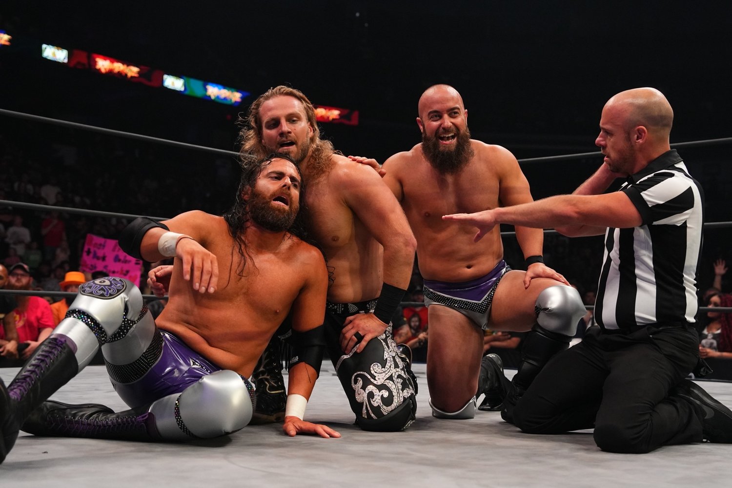 John Silver, right, takes in a victory alongside “Hangman” Adam Page, center, and Alex Reynolds, left.