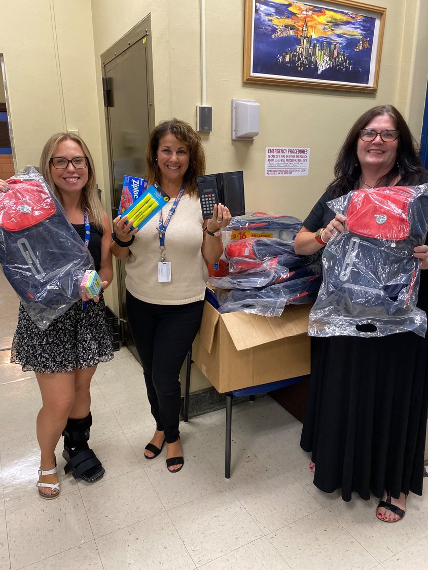 Social worker Randie Bauman-Renna, along with teachers Laura Pulitano and Erin Reilly, unpacked the backpacks the Kiwanians delivered to them at Howard T. Herber Middle School.