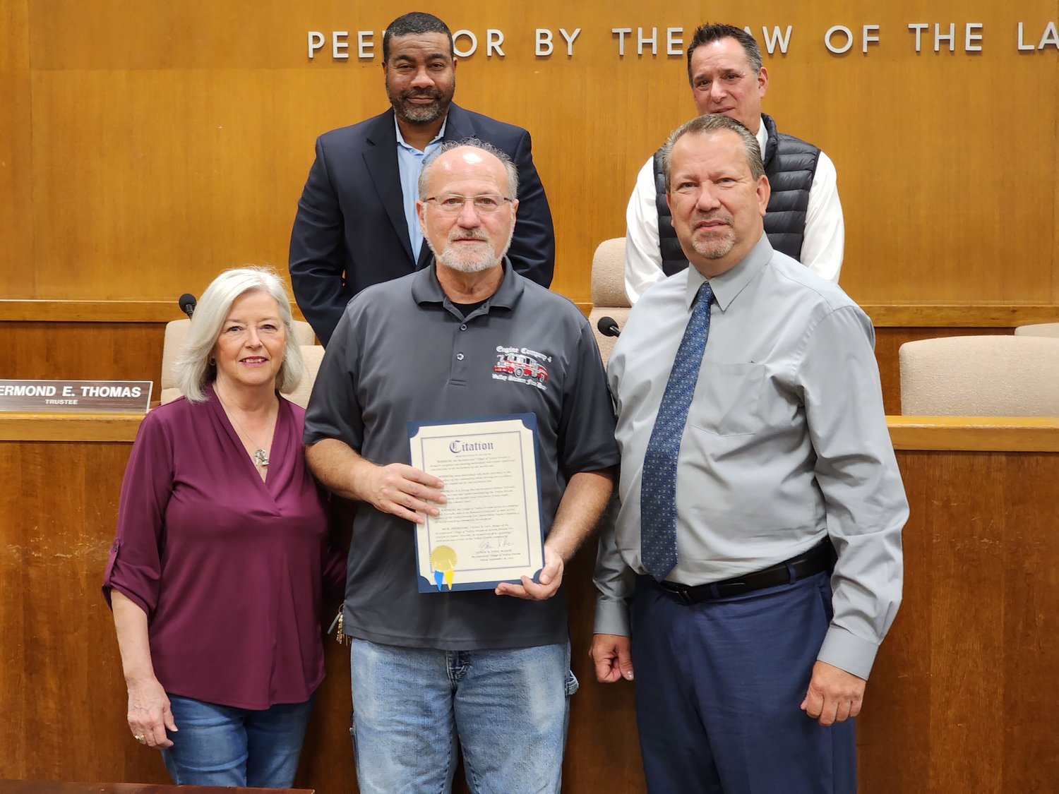 Resident Dennis Verriello, center, received a citation from Mayor Edwin Fare for leading the way in establishing the village’s Annual Classic Car Show. Verriello’s  wife, Kathy, is at left.