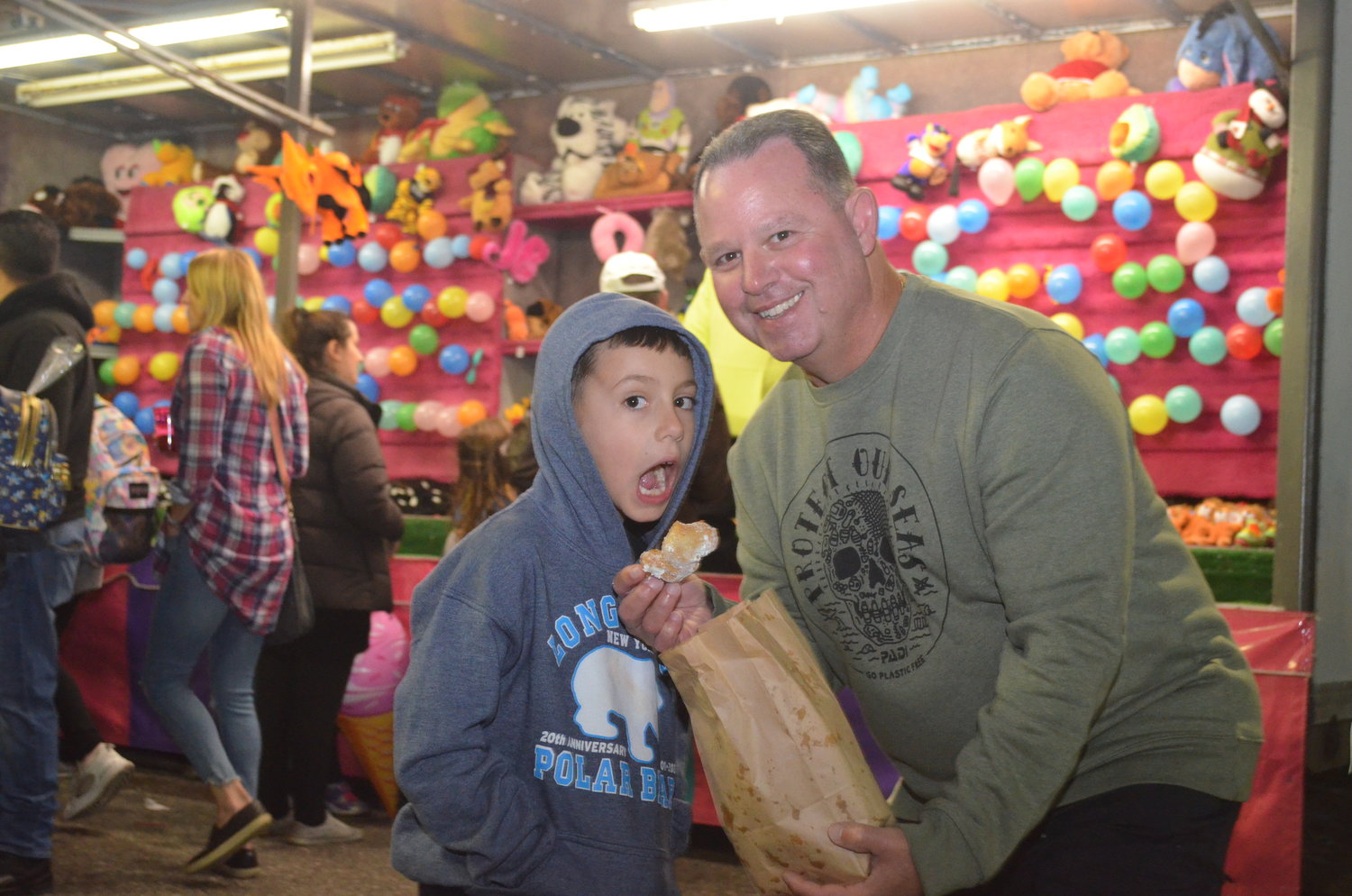 Joseph Landerer, 6-years-old, and Jason Landerer enjoying zeppoli’s at the Octoberfest.