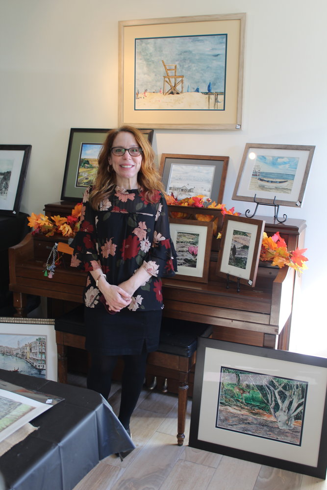 Painter Lori Blau of Oceanside, stands next to her original watercolors featured this past weekend at the Fall Arts and Crafts Exhibit hosted by Old Spirit Distillery.