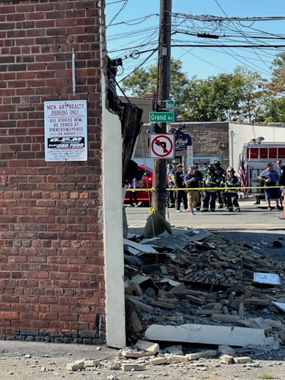 Baldwin firefighters securing the scene of a partially collapsed building façade at the intersection of Grand Avenue and Smith Street.