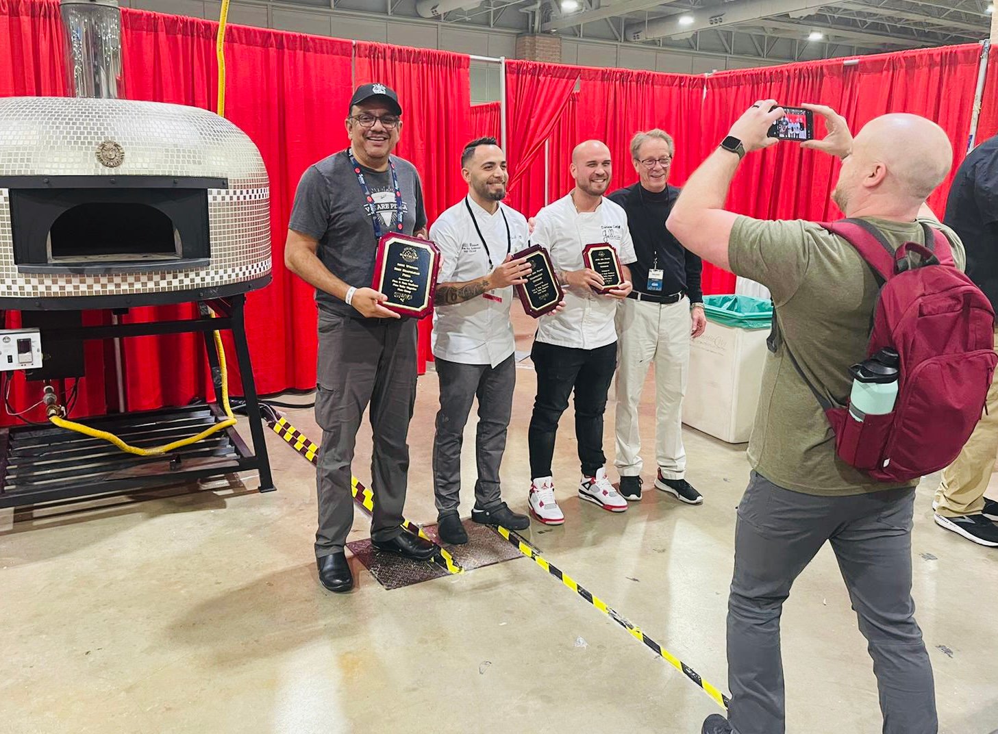 Onion Tree co-owner and chef Jay Jadeja, far left, took a photo with second and third place winners Daniele Gagliotta and Daniele Caridi, and show director Bill Oakley at the Pizza and Pasta Northeast 2022 Competition.