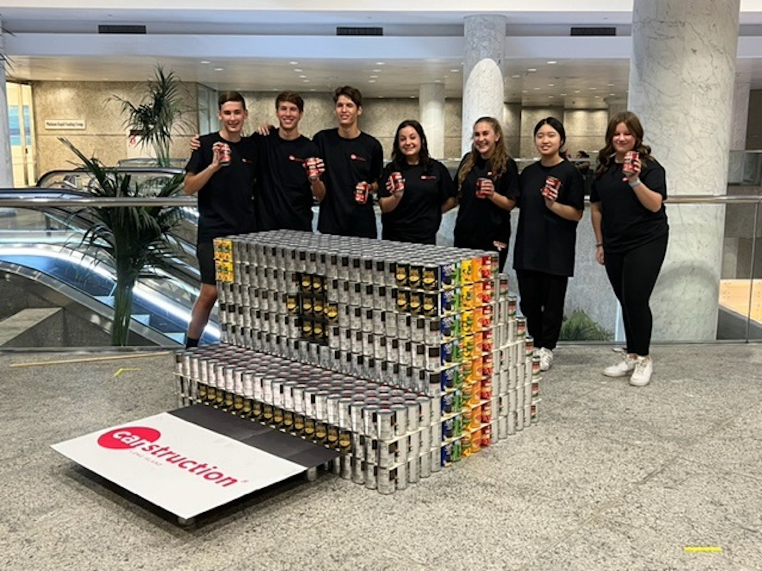 East Rockaway High School students with their Canstruction creation, a Polaroid camera constructed of 1,678 cans of food.