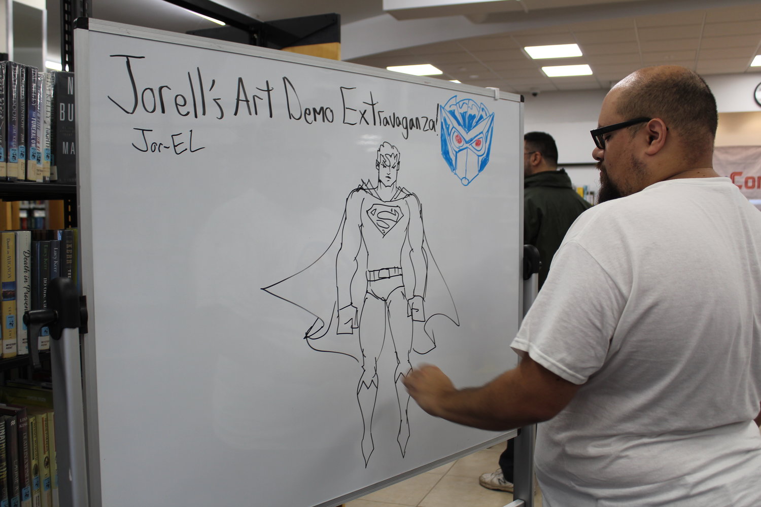 Illustrator Jorell Rivera sketches out Superman, teaching eager youngsters how to draw characters.