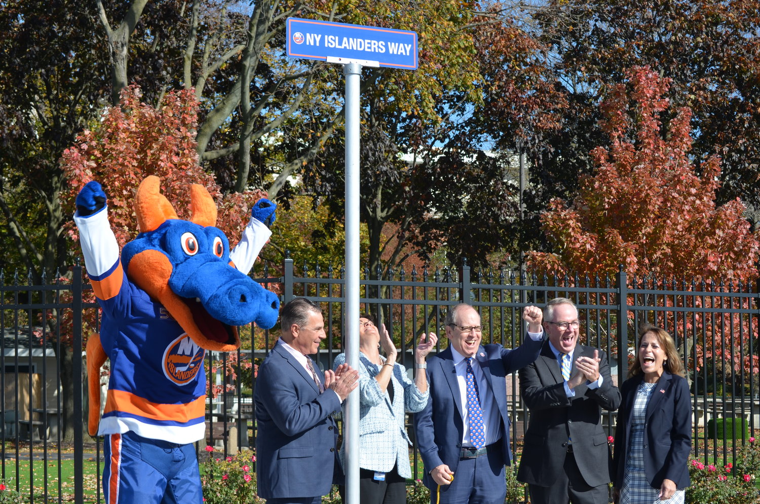 Coming together to unveil the new street sign, with the help of Islanders mascot Sparky the dragon, were Islanders co-owner Ledecky and Hempstead Town Supervisor Don Clavin, third and second from right.
