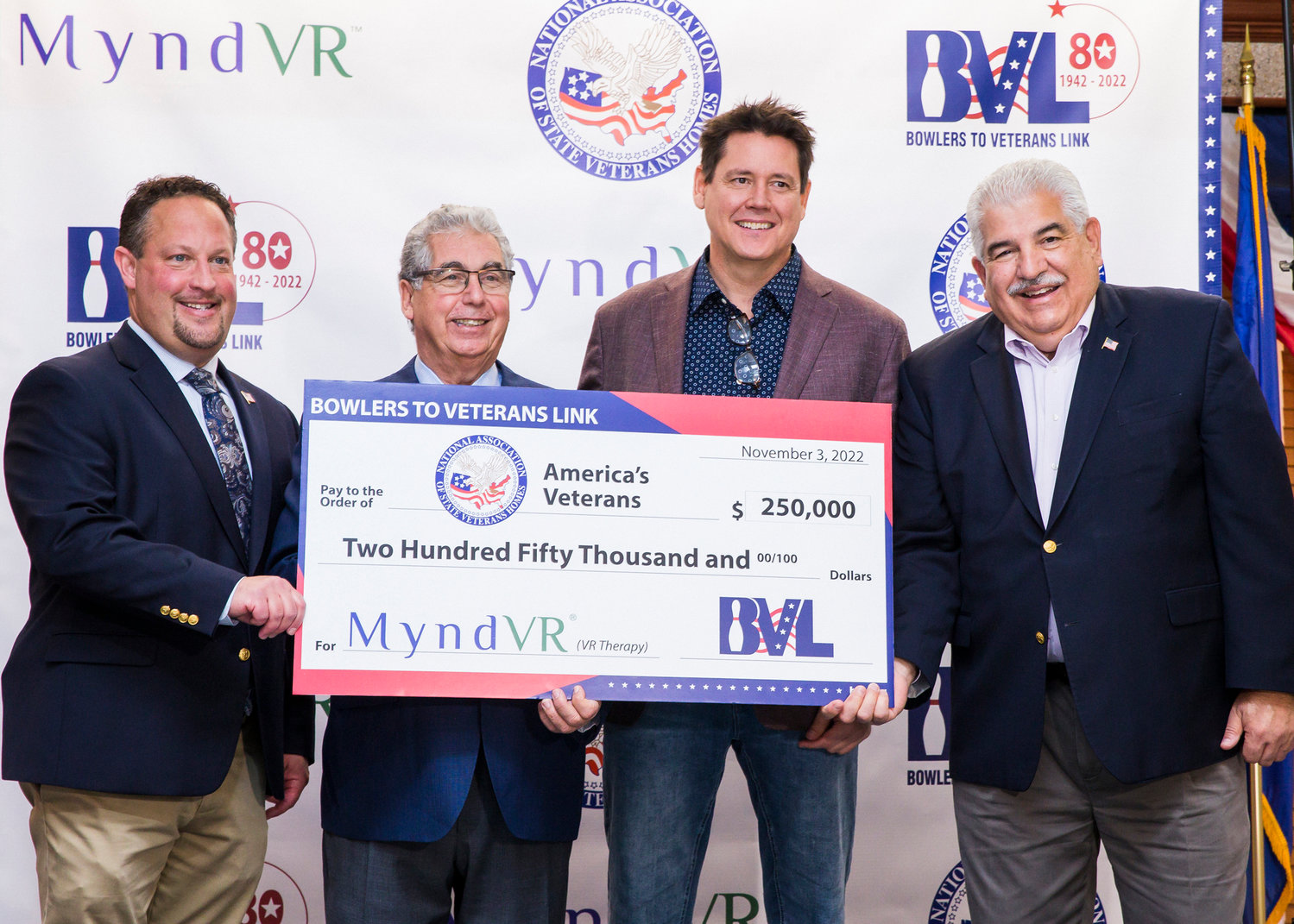 Bowlers to Veterans Link presents a $250,000 check to the National Association of State Veterans Homes to fund virtual reality therapy programs for veterans. From left: Jonathan Spier, deputy executive director of Long Island State Veterans Home, John LaSpina, president of Maple Family Centers and Bowlers to Veterans Link board chairman, Chris Brickler, MyndVR founder and CEO, and Fred Sganga, executive director of Long Island State Veterans Home.