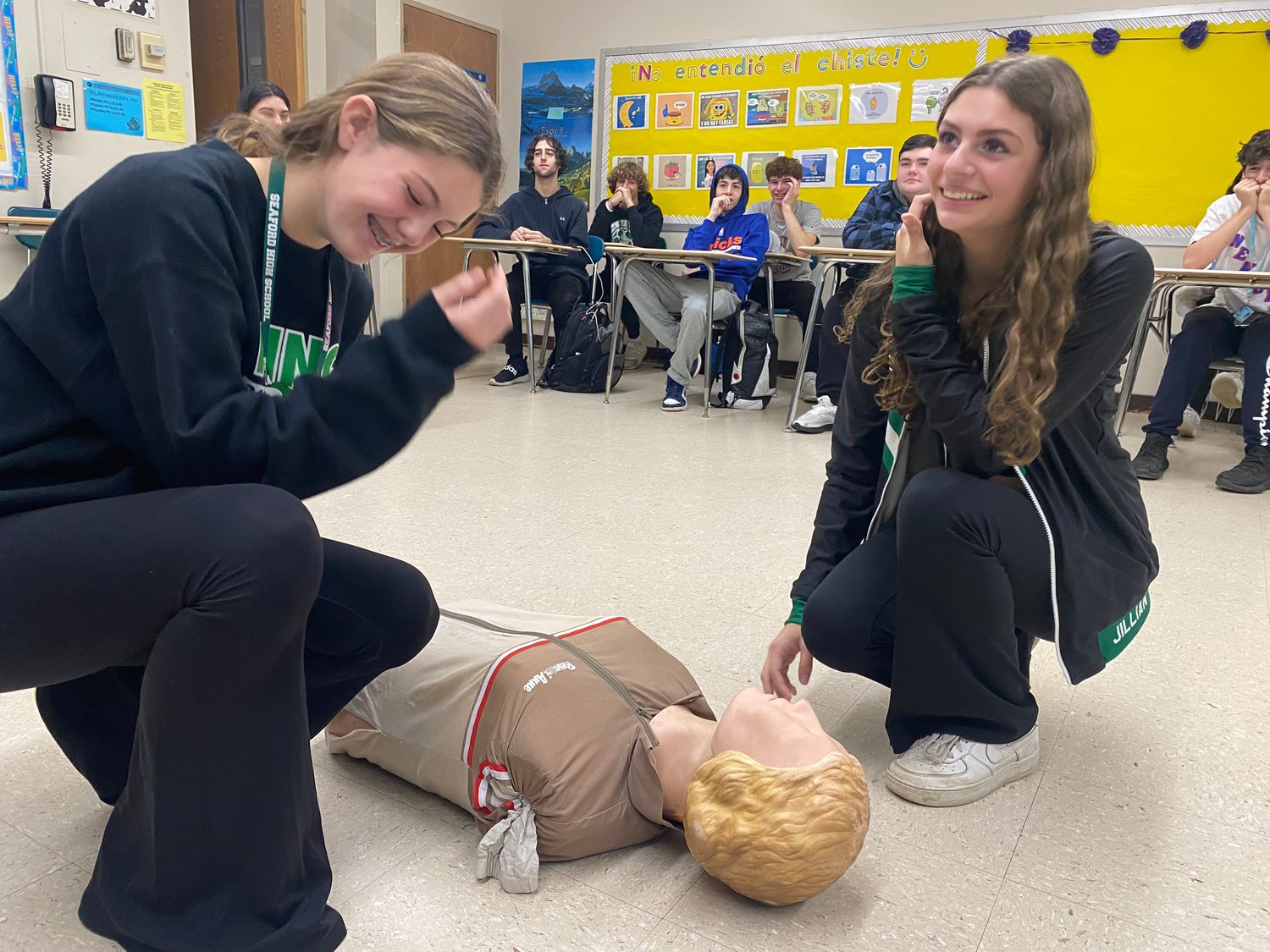 Students Megan Bloom, right, and Jillian Bartolomeo learn how to apply emergency medical services’ skills, practicing on a dummy.