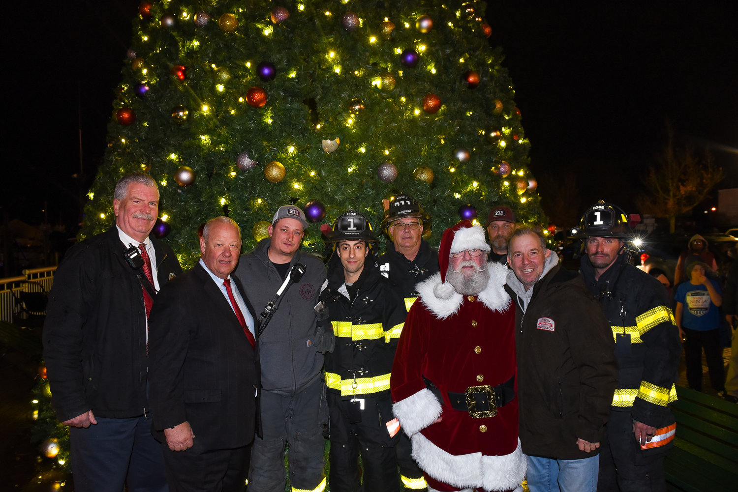 Following the tree lighting, Mayor Robert T. Kennedy, elected officials, and members of the fire department gathered around Santa Claus for photos.