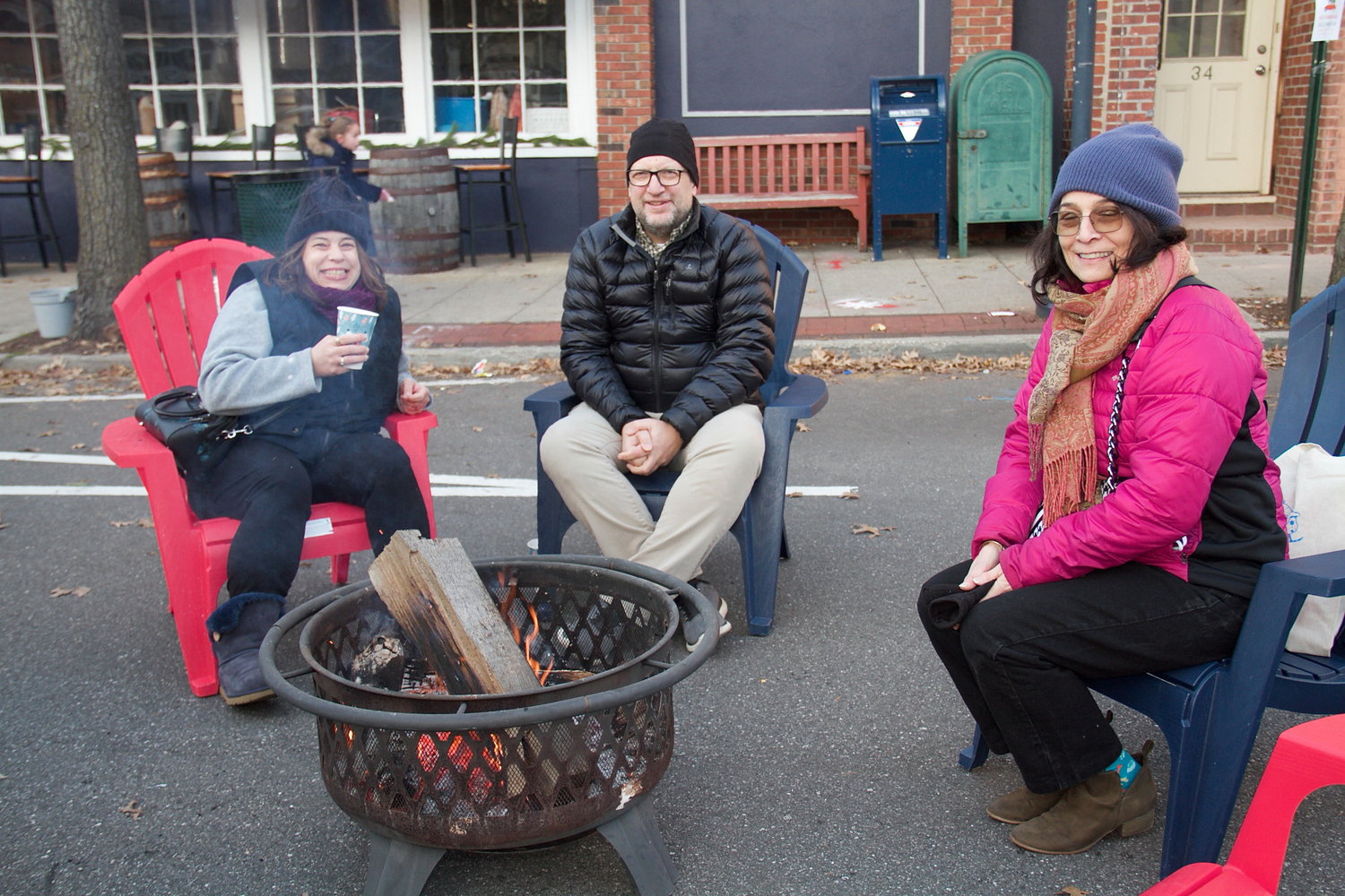 Many people took advantage of the fire pit on Audrey Avenue, including Beth and Dan Chahbazian, left, and Liz Miazza.