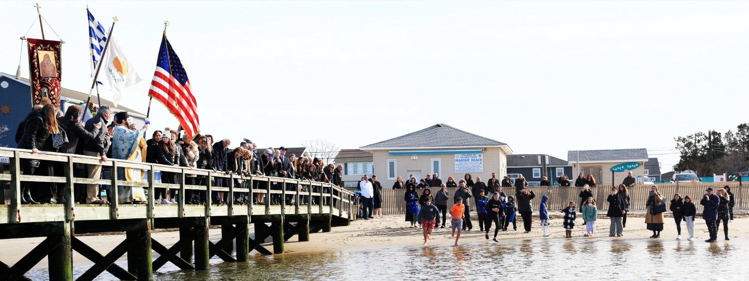 The congregation of Panaghia of Island Park Greek Orthodox Church lines the pier and beach of Masone Beach for the celebration of the Blessing of the Waters.