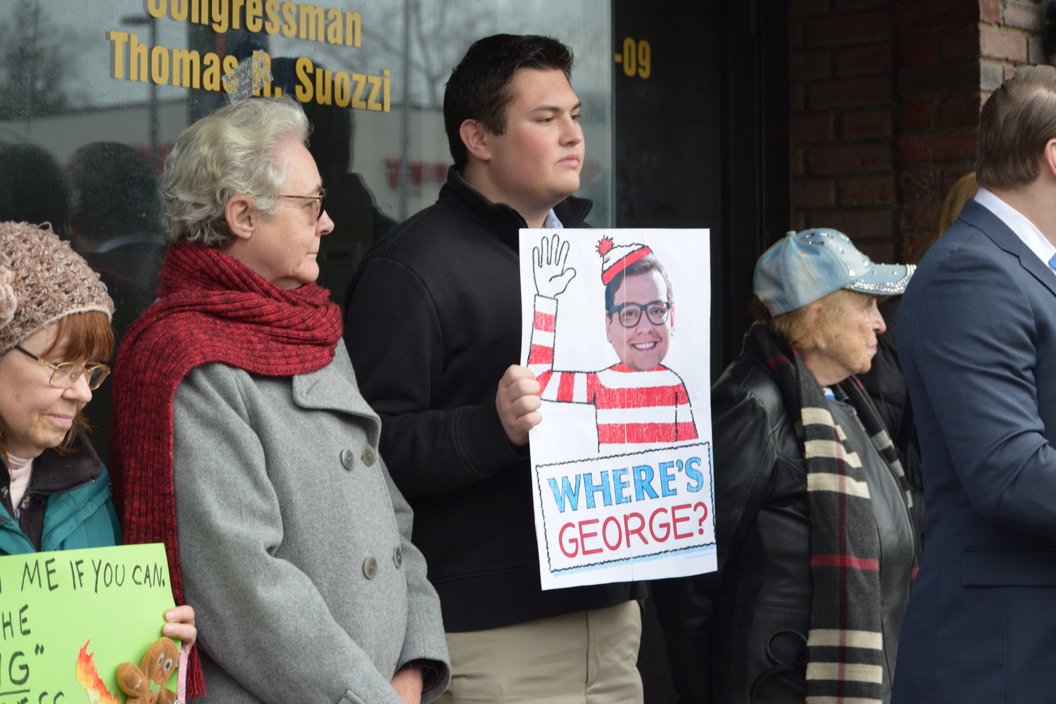Aidan Davis, a leader of the group Concerned Citizens of NY-03, with a sign likening U.S. Rep. George Santos’s reluctance to appear in public to ‘Where’s Waldo?’