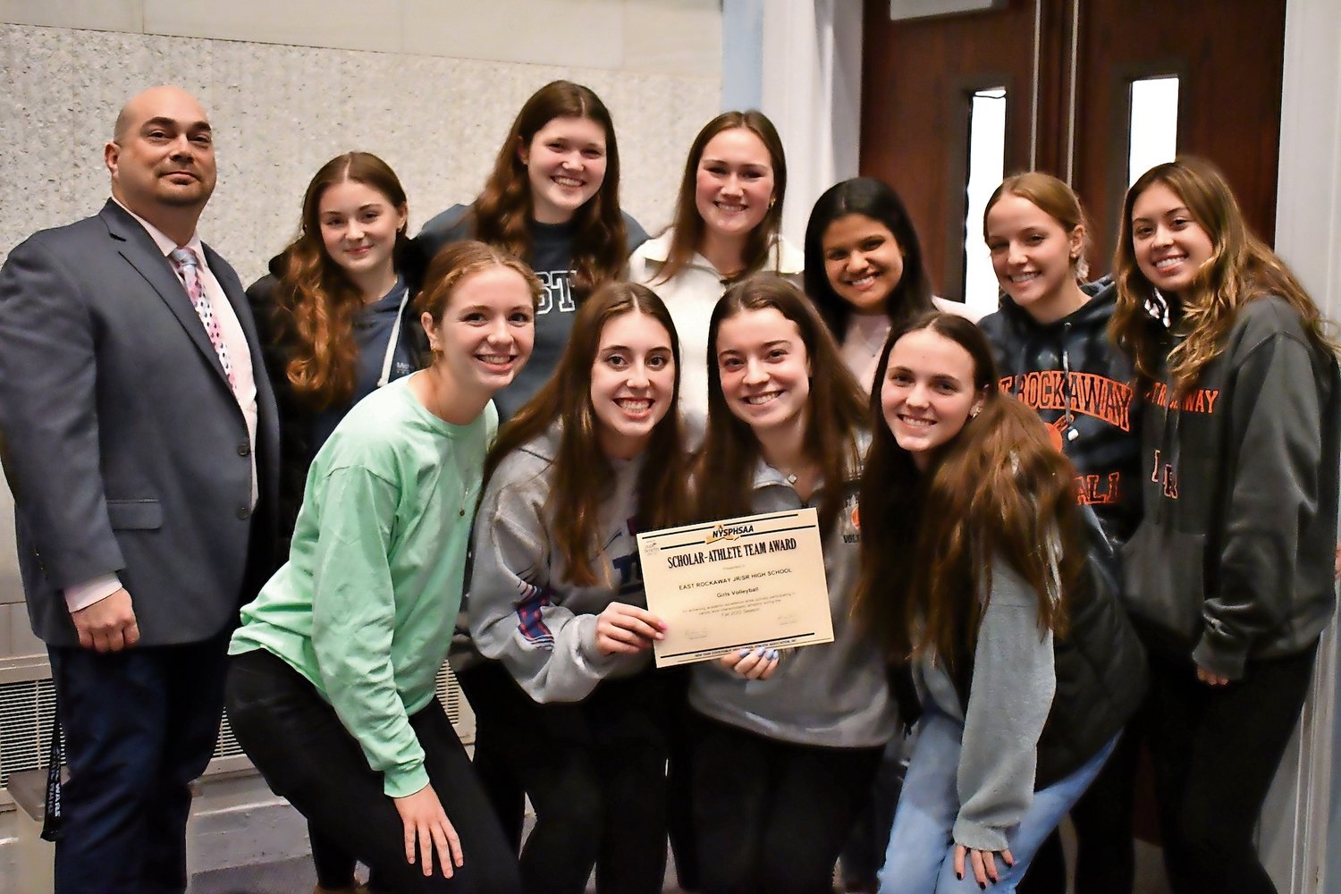 Members of East Rockaway Jr./Sr. High School girls’ volleyball were honored as a Scholar-Athlete team with Athletic Director Gary Gregory, far left.