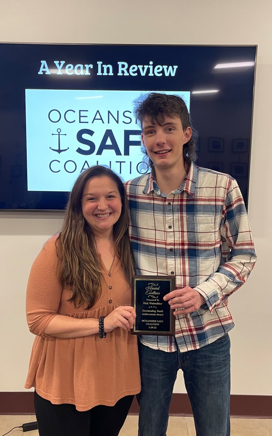 Alison Erickson, project coordinator for the Oceanside SAFE Coalition, presents Nick Wollweber with the Outstanding Youth Award for his many contributions to the coalition.