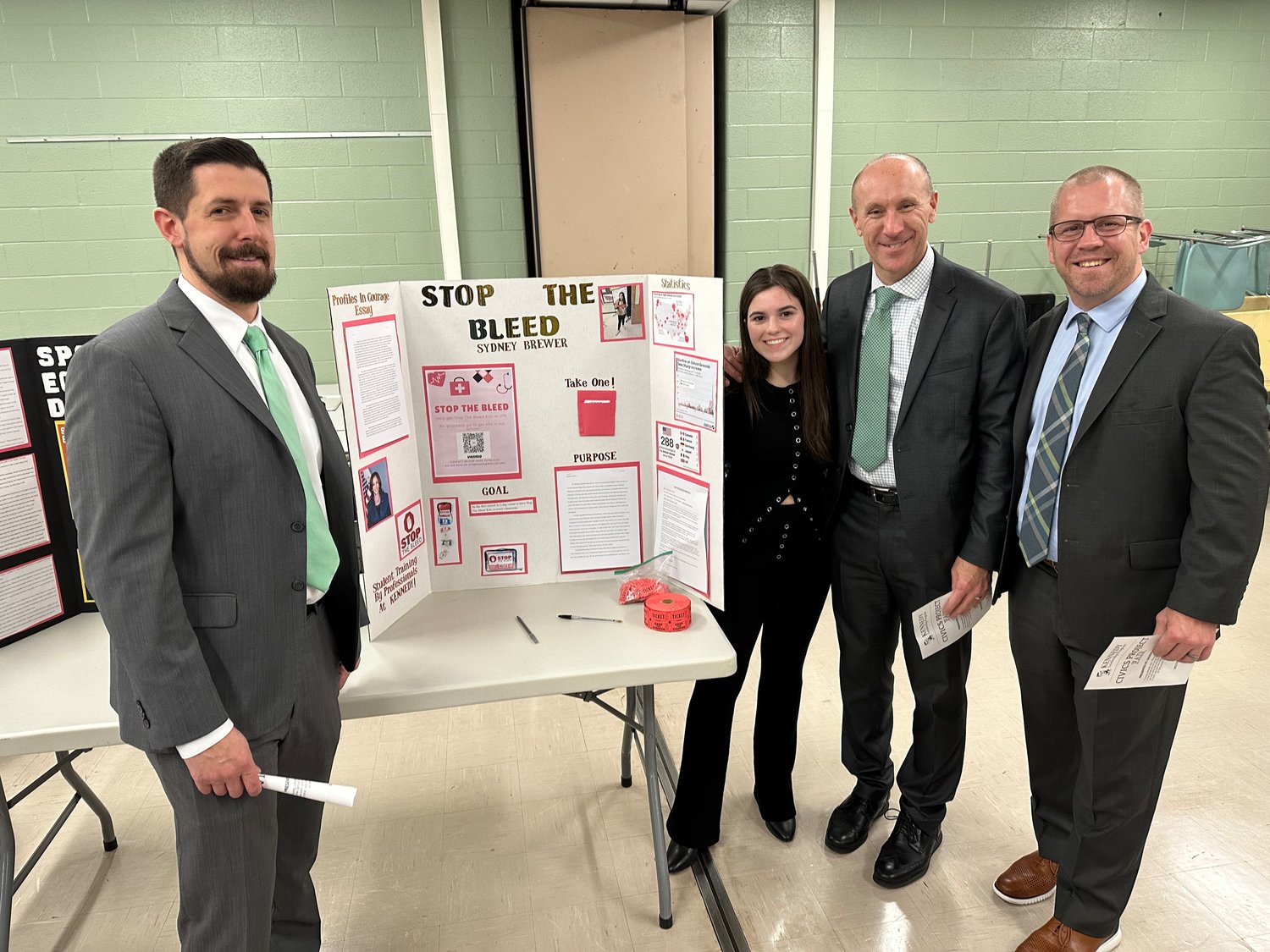 Sydney Brewer with, from left, Kennedy High Assistant Principal Daniel Jantzen, Principal Gerard Owenburg and Assistant Principal Jeff Cronk at the school’s civics fair, where Brewer presented her ‘Stop the Bleed’ project idea.
