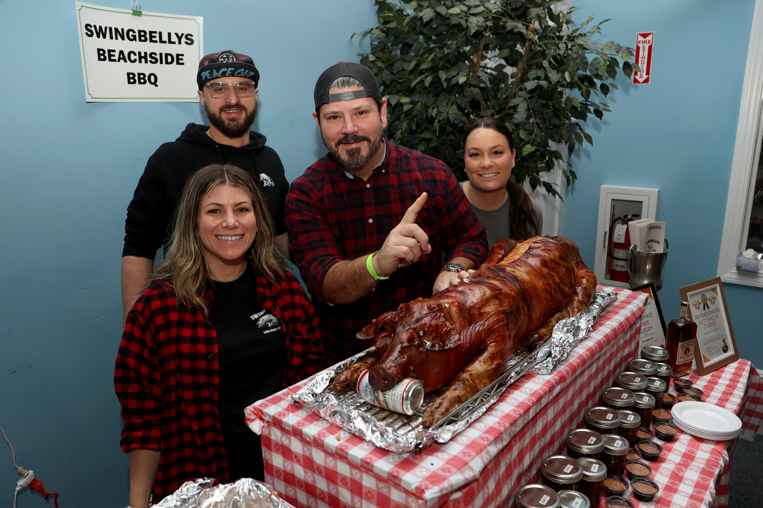 Swingbelly’s Beachside BBQ owner Dan Monteforte with staffers Meg Hutnick, Jeremy Rosen, Ashley Sgambati and Gunner, the roast pig.
