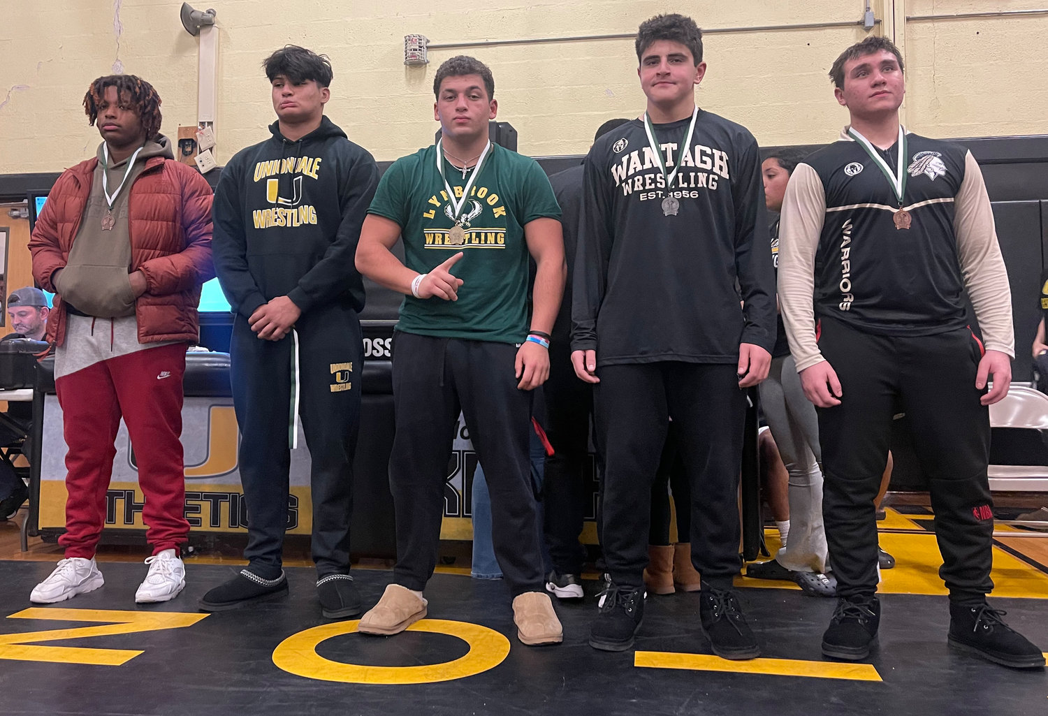 Lynbrook's Ralph Caputo, middle, took home the 215-pound title at last Saturday's qualifier hosted by Uniondale.