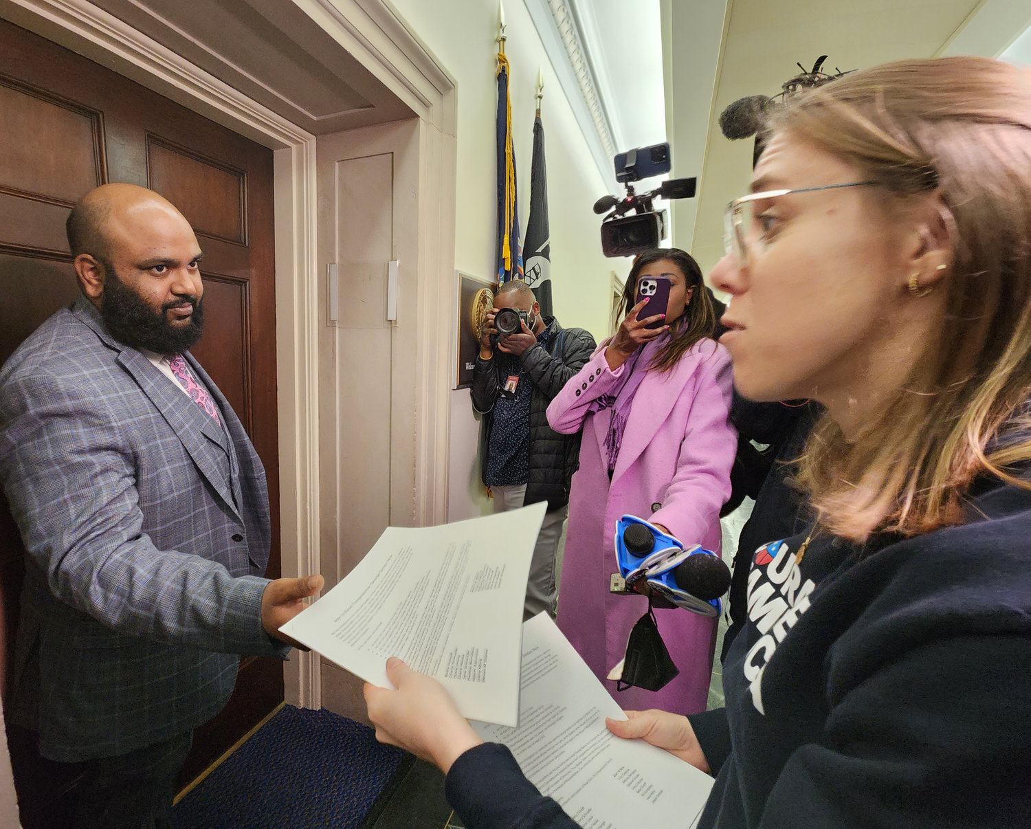 Casey Sabella, far right, an organizer with the group Courage for America, delivers petitions from constituents of the 3rd Congressional District to a staffer outside the Washington office of U.S. Rep. George Santos on Tuesday. Sabella and others called on Santos to resign during a trip to Capitol Hill ahead of President Biden’s State of the Union address.