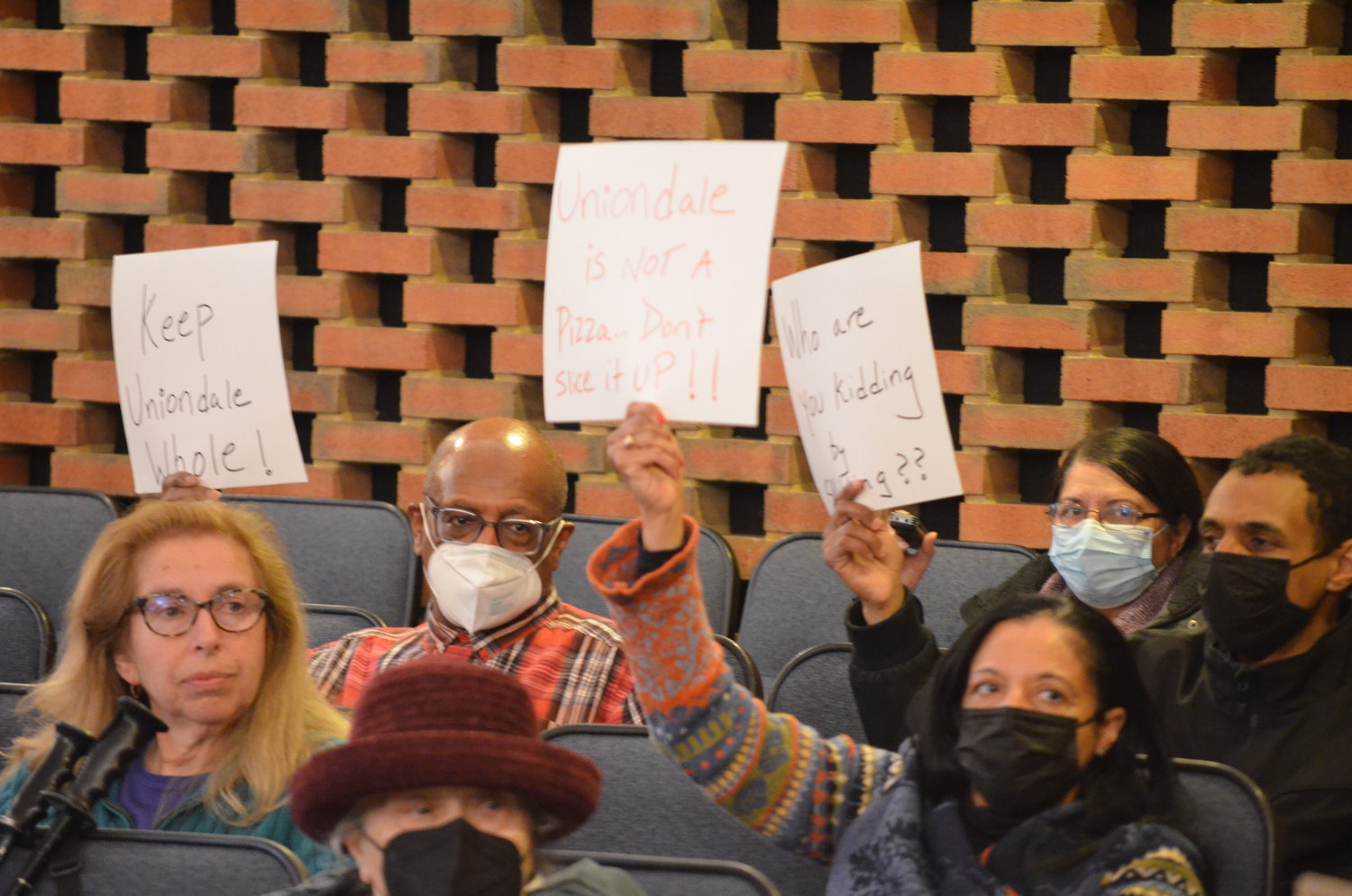 People filled the observer area, holding handmade signs demanding their communities be kept whole. Town officials were getting ready to approve a new map redrawing district lines for local elected officials — a map many of them opposed.