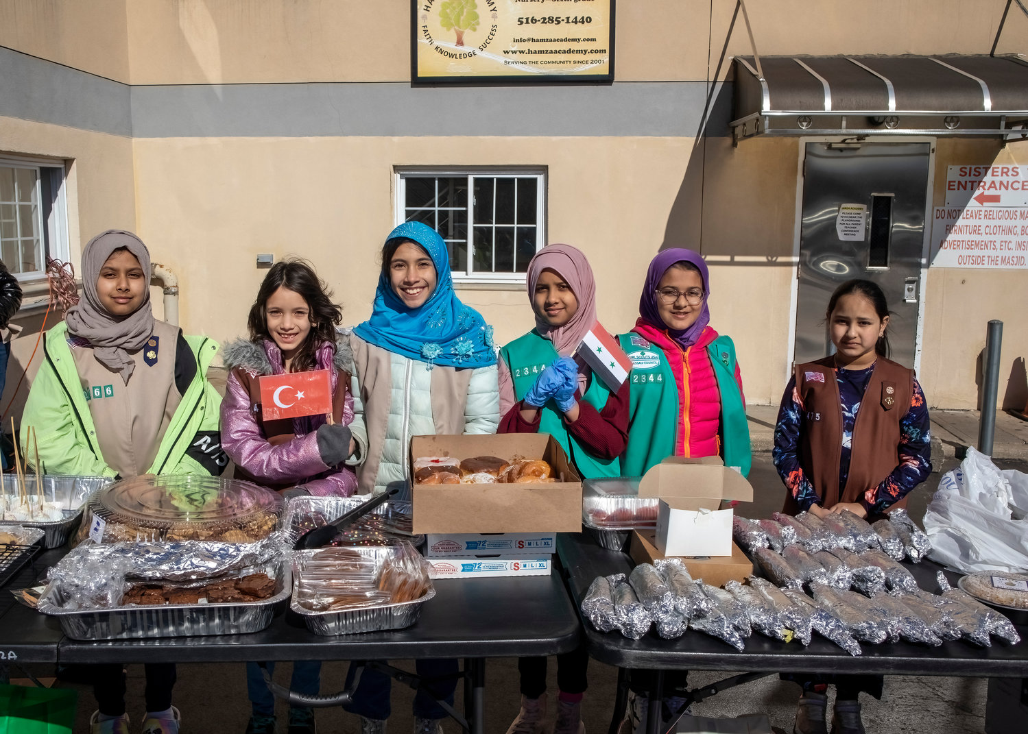 Valley Stream Girl Scout Troops launched a bake sale to raise money for the earthquake victims in Syria and Turkey. Girl Scouts Afifa Patel, left, Zehra Beskardes, Maryam Beskardes, Sakeena Vaseen, Aleena Rana, and Hiba Anwarulla man the tables.