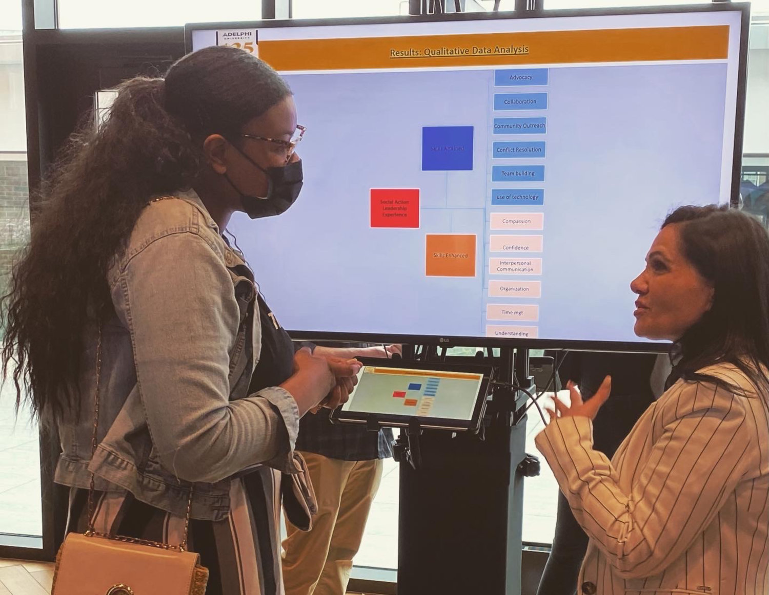 Marcella Pizzo, right, talked to a student studying social work about research at Adelphi University’s research conference.
