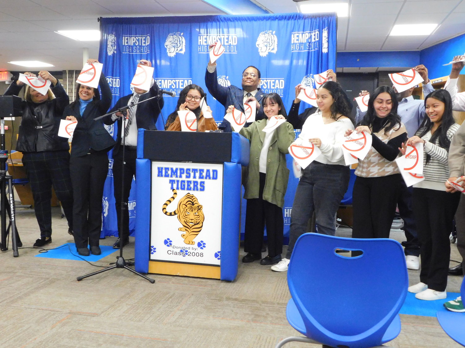 Hempstead High senior Nashlie Morales, surrounded by school administrators and board members, symbolically ripped the word RECEIVERSHIP in two. Hempstead High and ABGS Middle School are now in good standing with New York State.