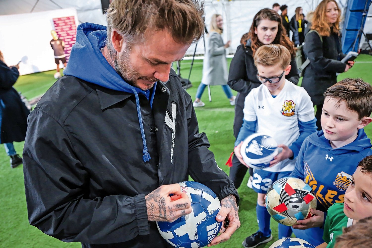 David Beckham signs balls for some of the 400-some young soccer players that gathered at the Mitchell Athletic Complex on Saturday to meet him.