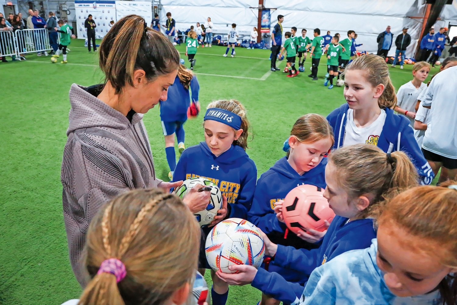 Carli Lloyd signs balls for some of the 400-some young soccer players that gathered at the Mitchell Athletic Complex on Saturday to meet her.