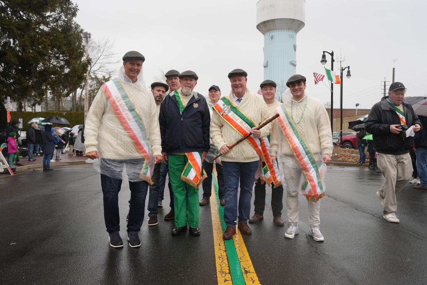 Parade Grand Marshal Tommy McNicholas, third from near left, marches down Maple Avenue with shillelagh in hand.