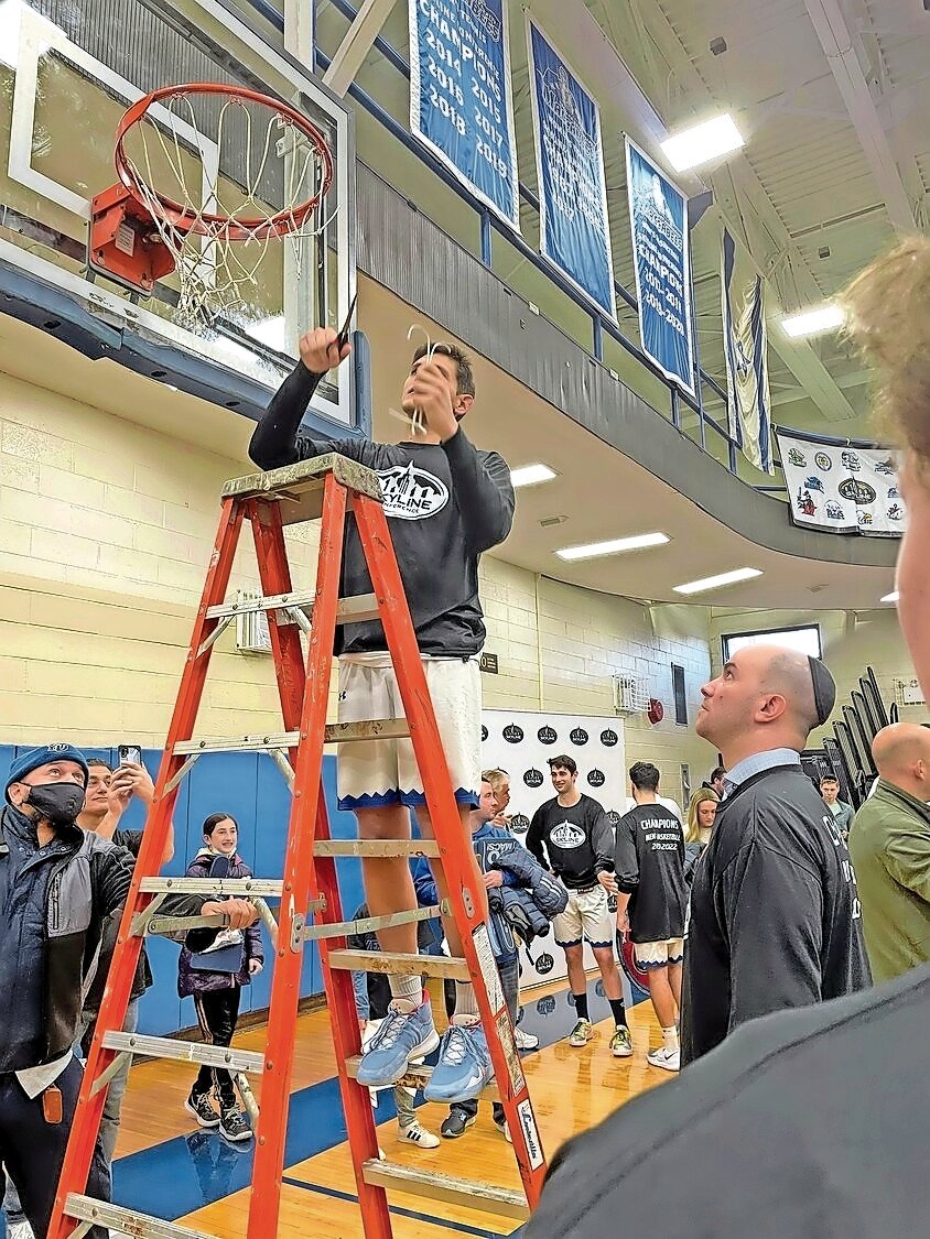Yeshiva University men’s basketball head coach Elliot Steinmetz will receive the first-ever the Jewish Sports Heritage Association’s Marty Riger Outstanding Jewish Coach of the Year Award. At right, Steinmetz watched Lawrence native Gabriel Leifer cut the net after winning the 2021-22 Skyline Conference title.