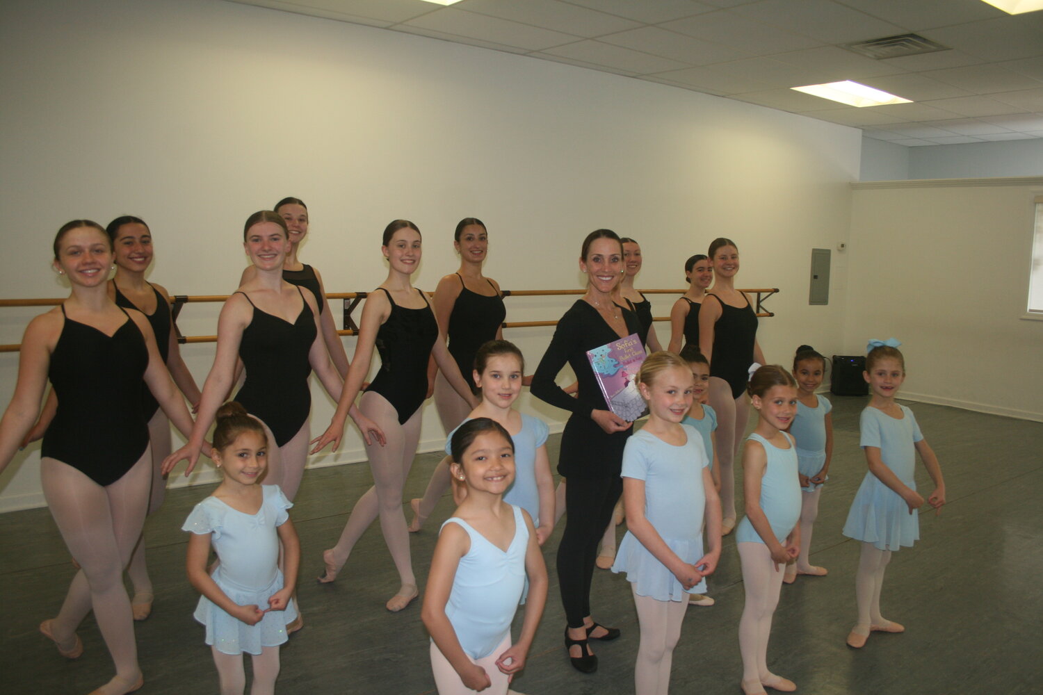 Sara DeGennaro with her students in her Malverne studio, Tap to Pointe Dance Center. DeGennaro recently published a children’s book about ballet.