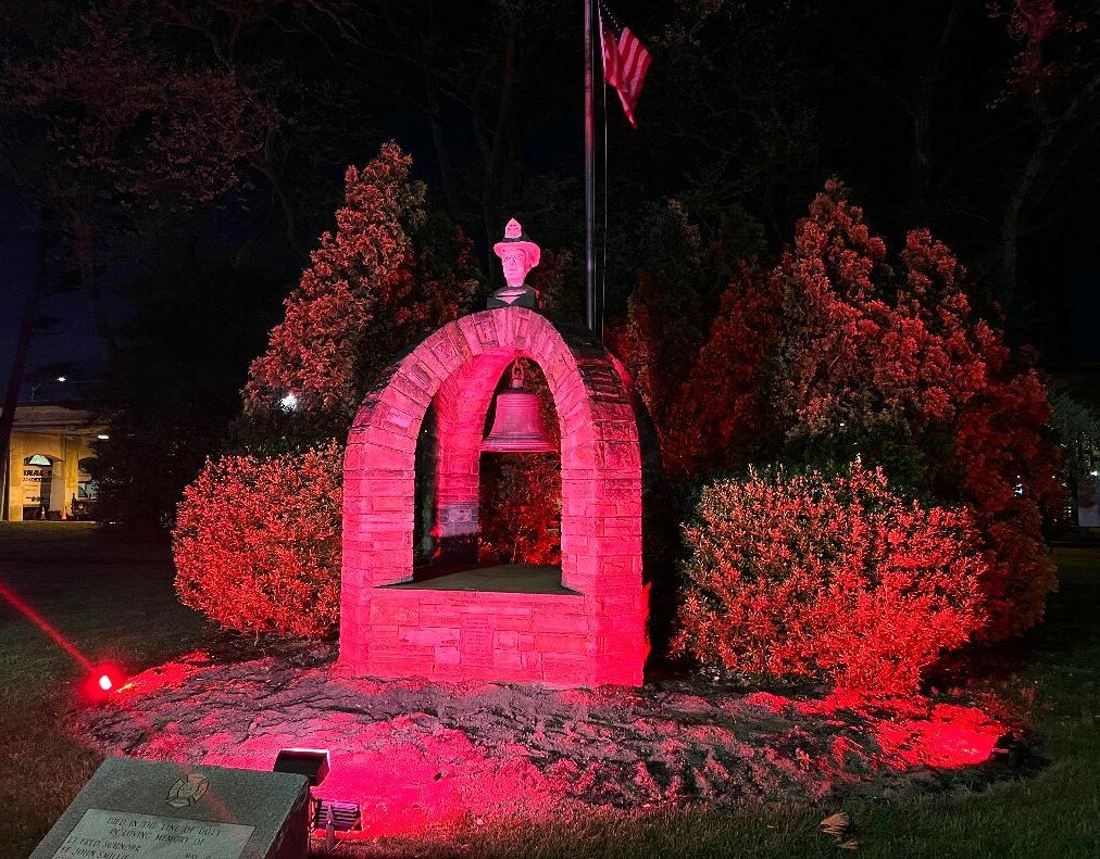 The Lynbrook Firefighters Memorial on Sunrise Highway basked in red in memory of the village’s fallen firefighters.