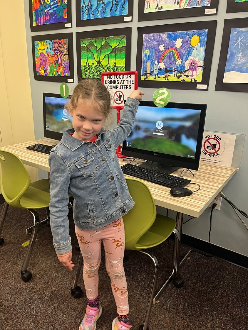 Kindergarten student Samantha Gilbert displays her artwork entitled “I am not just a scribble” during the student art exhibition at the RVC Public Library.