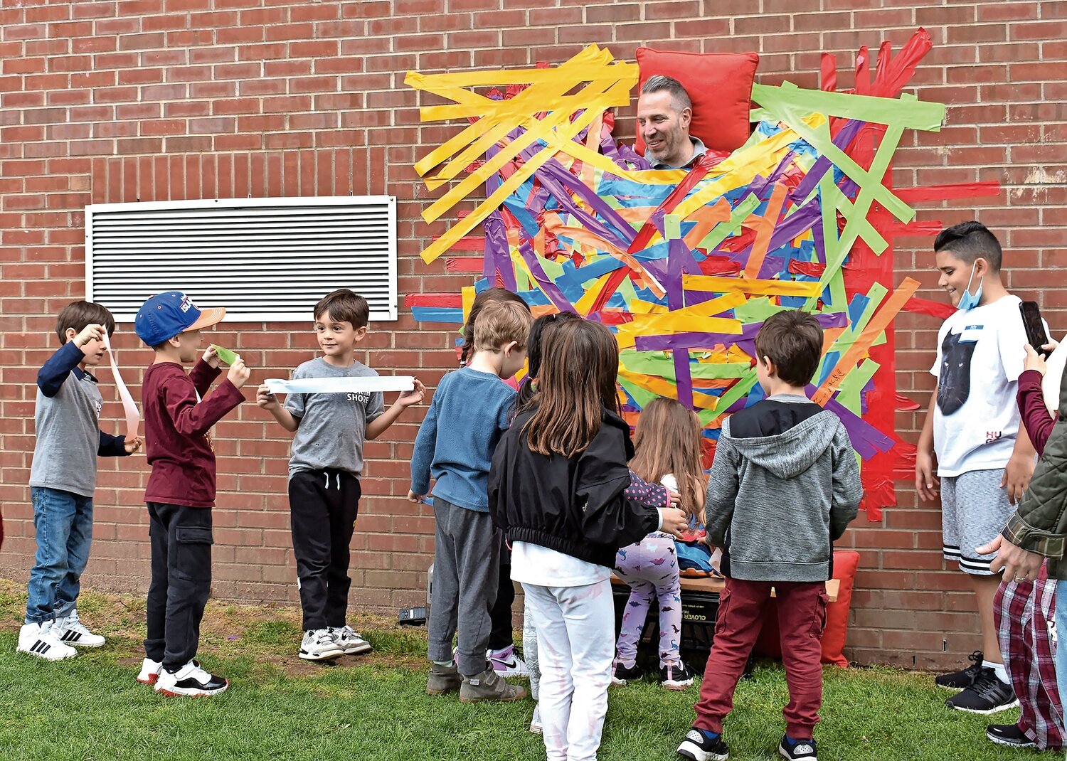 Students had a blast taping Principal Peter Rufa to the wall of Glen Head Elementary School.