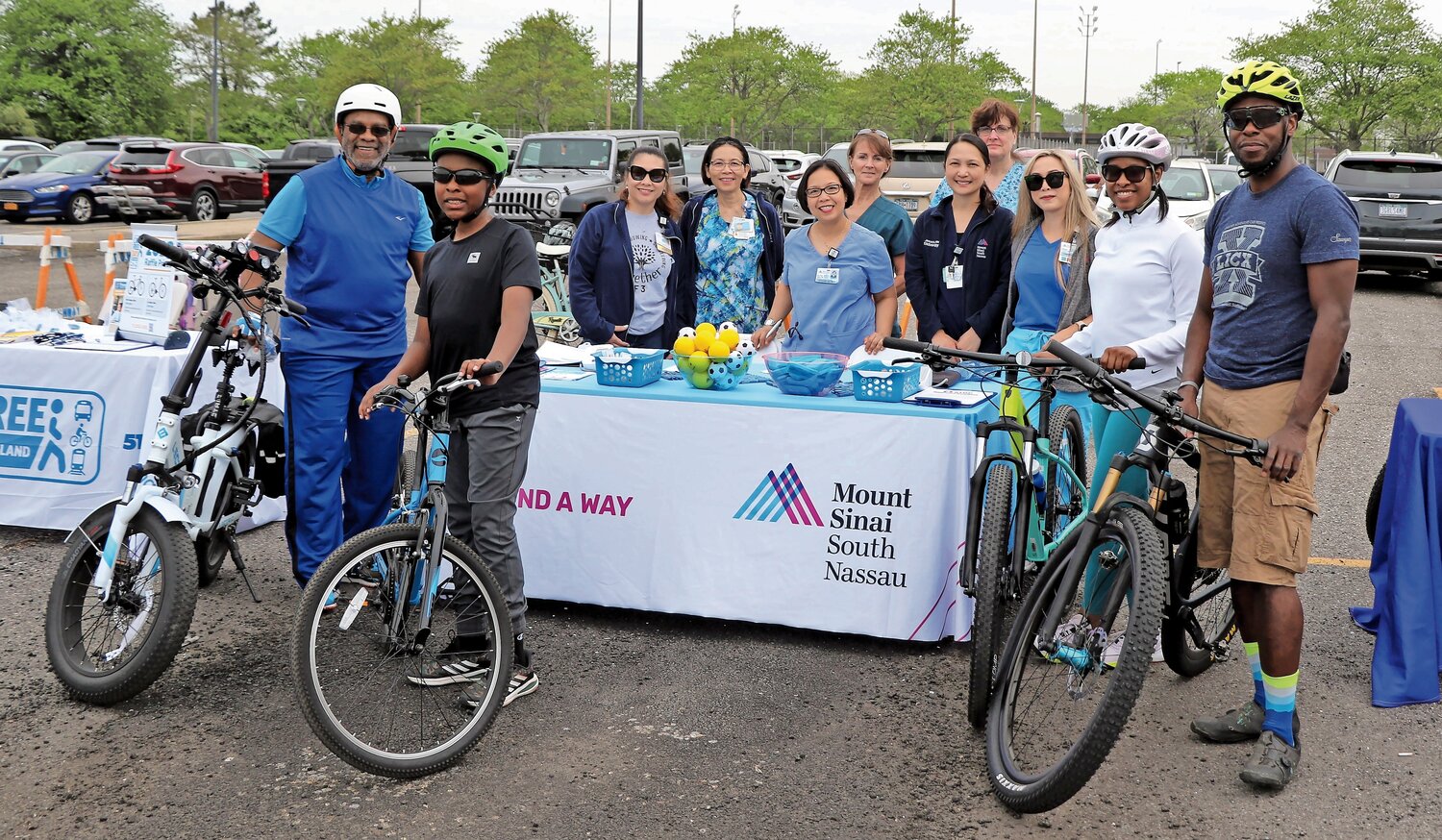 Lionel Senior, far left, with his grandson Isaiah, right of him, along with Mount Sinai staff and other bicyclists at the Mount Sinai blood pressure check table at the Bike Parade last Saturday.