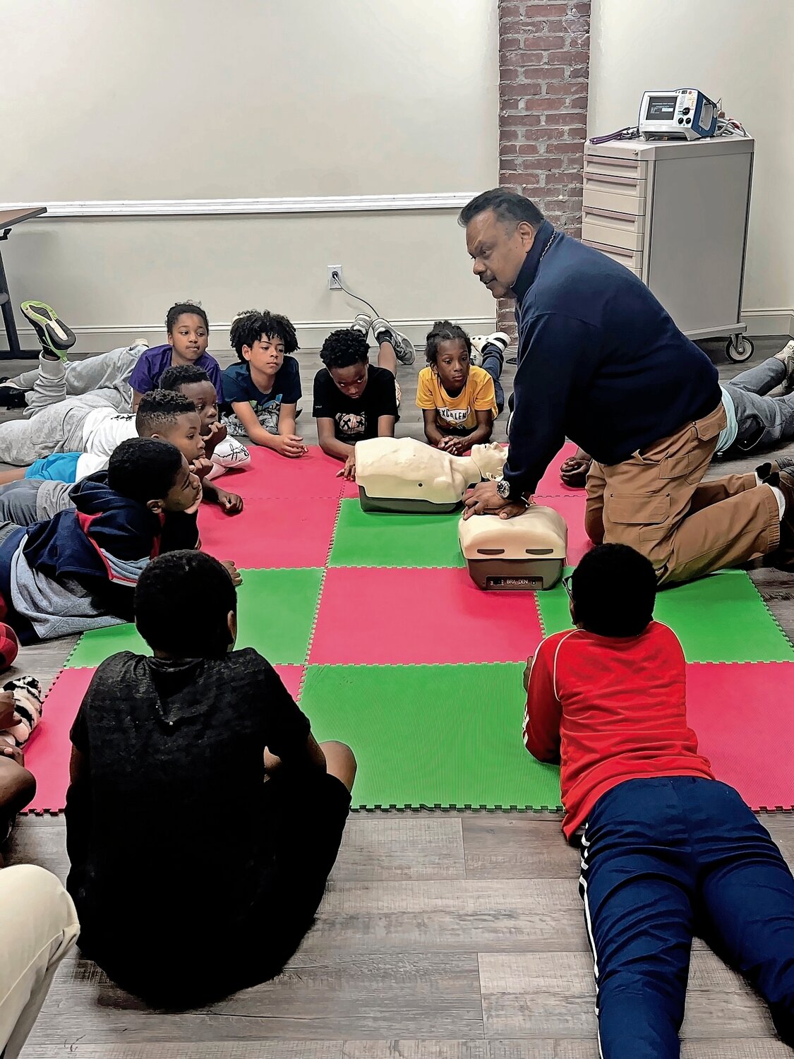 Richard Rattan performing CPR and teaching fifth grade students at Lenox Elementary School important safety lessons.