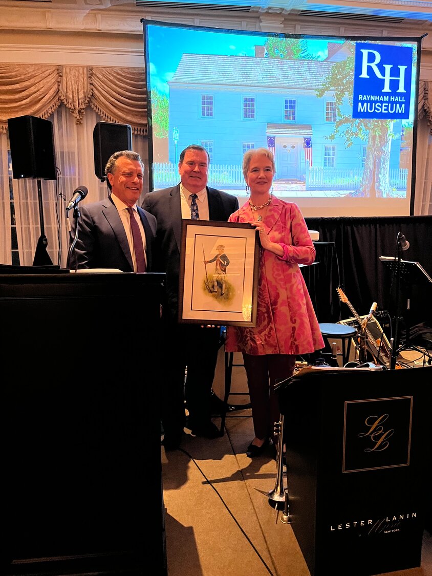 Will Sheeline/Herald
Stuart Richner, left, was presented with a drawing of a Revolutionary soldier by John Canning, the evenings master of ceremonies, and Harriet Clark, Raynham Hall’s executive director.