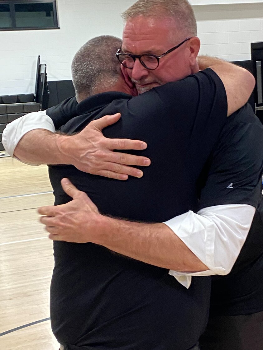 Superintendent Dan Rehman embraces Trustee Joe Magaraci moments after his victory.