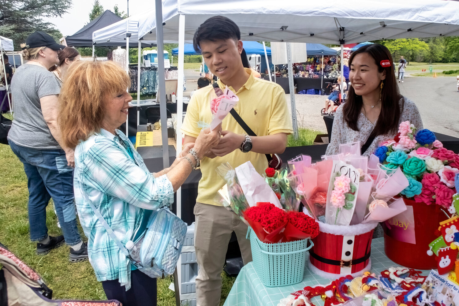Nancy Palmer, left, from Baldwin checked out the handmade flowers by Alan Lu, center, and Macy Lai.