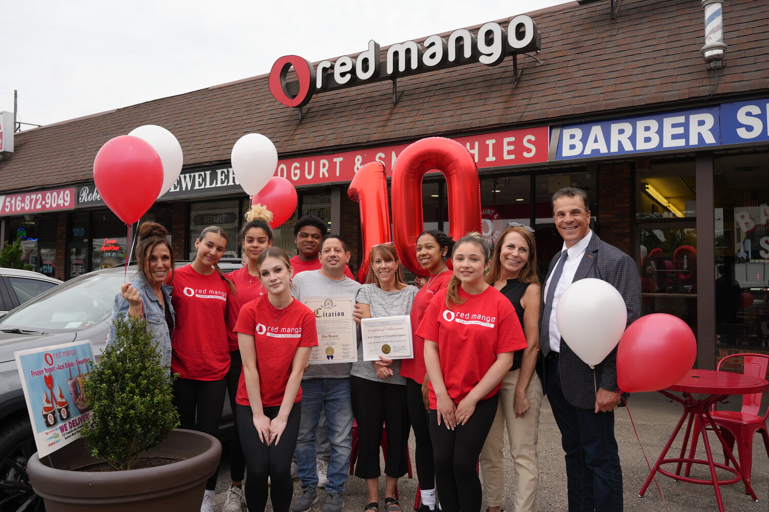 Chris Cianciulli, center left, celebrates a decade of operating his Red Mango in Franklin Square  on May 13 with his staff and local elected officials.