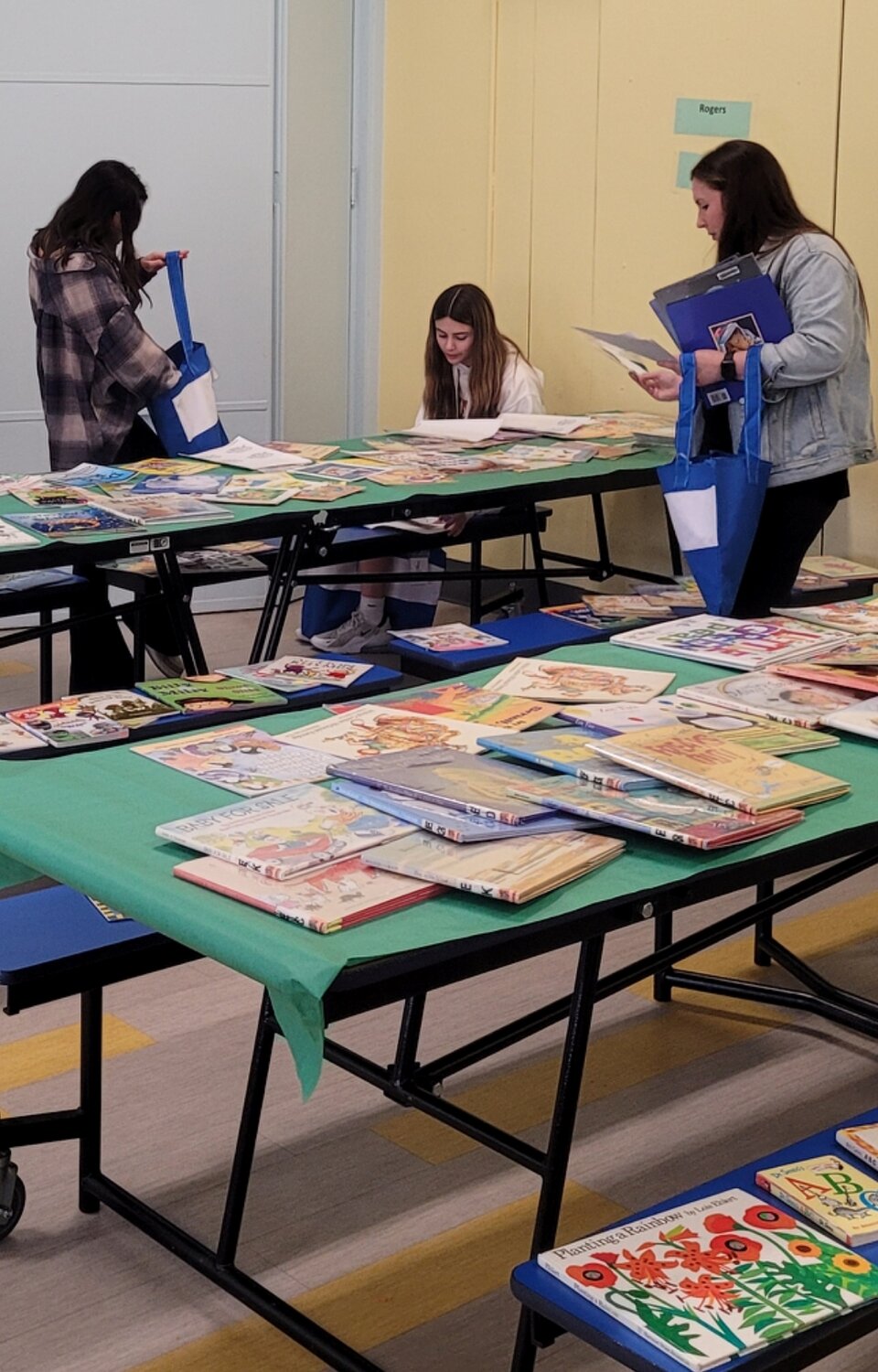 Volunteers sorting books for the Take10 program bag.