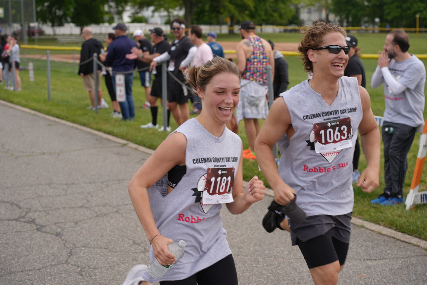 Emma Razukiewicz and Ryan Friedman, far left, crossed the finish line together at the 16th Annual Robbie’s Run, which finished at Lakeside School in Merrick.