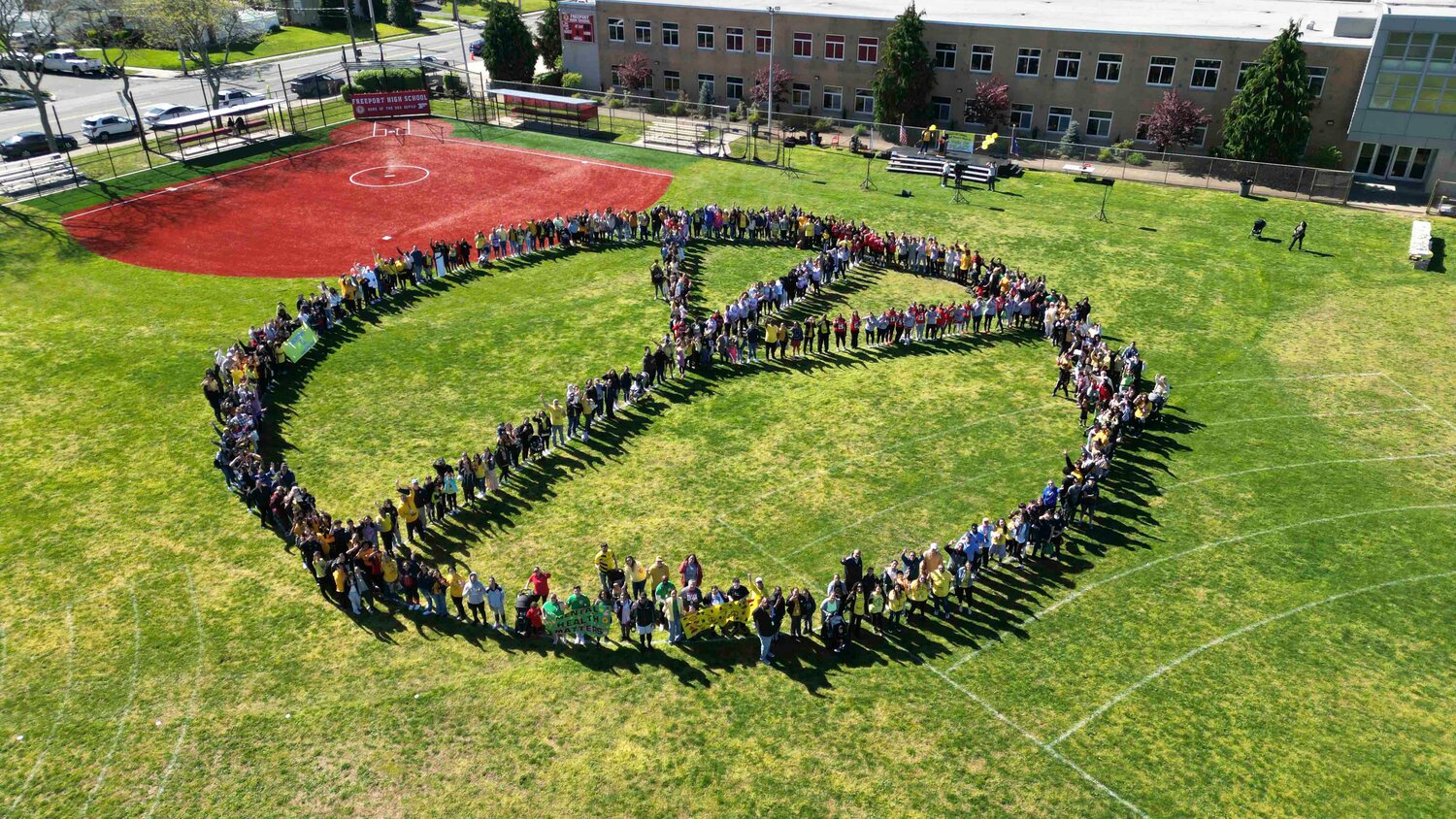 Participants of the 14th annual Freeport Cares Peace March create a human peace sign, symbolizing unity and solidarity.