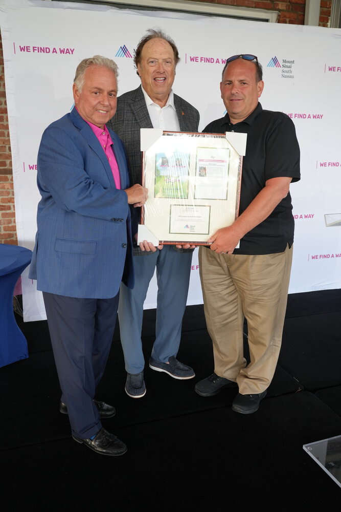 Golf committee co-chairs Mike Sapraicone, left, and Jeff Greenfield present Long Beach Fire Chief Scott Kemins with the Community Service Award during the golf tournament on May 15.