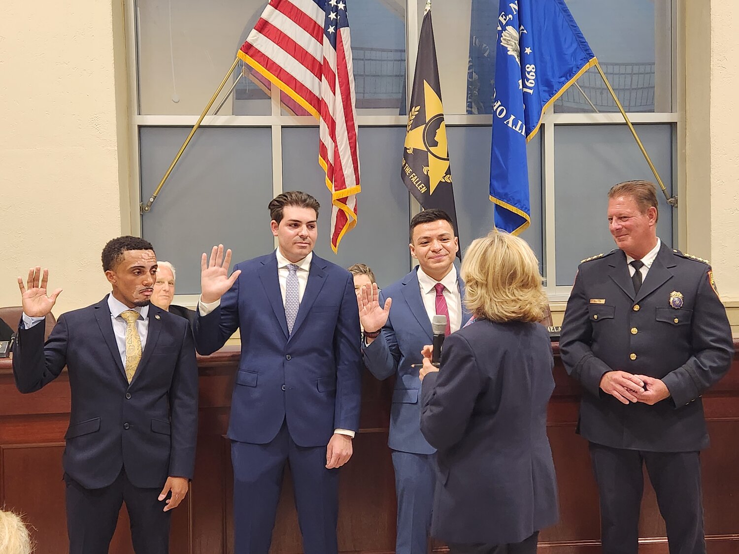 Glen Cove Police Chief William Whitton, far right, looked on as Mayor Pamela Panzenbeck swore in officers Jahrae O’Neill, far left, Erasmo Troia and Andres Sicam at City Hall.