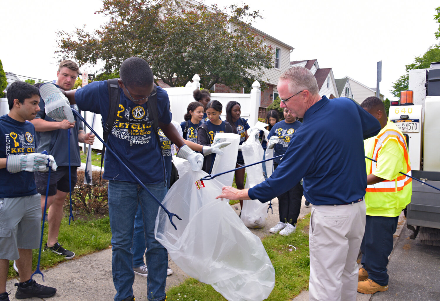 Hempstead Town Supervisor Don Clavin, right, gave Key Club students a hand in cleaning up the litter on the street.