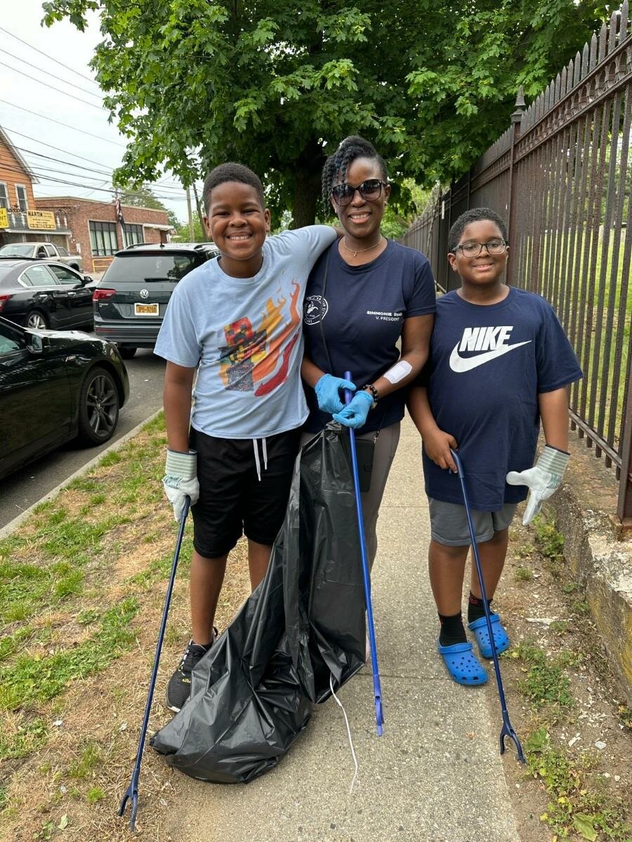 Simon Gordon, left, Locustwood Gotham Civic Association vice president Simmonie Swaby and Cameron Byrd worked hard filling up their trash bags during the cleanup event.