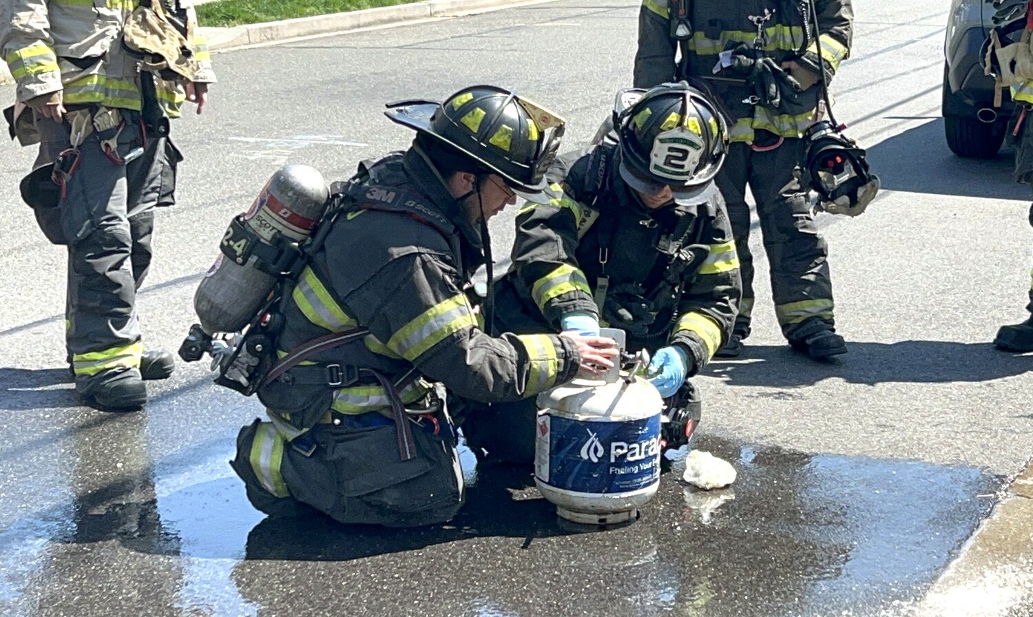 Lynbrook Fire Department firefighters inspect a leaking propane tank on Edmund Street on April 24.